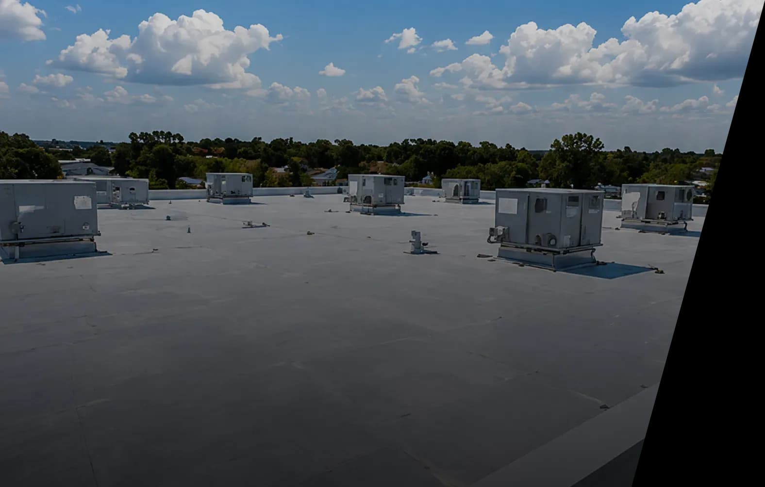 Commercial flat roof and rooftop units under an open sky