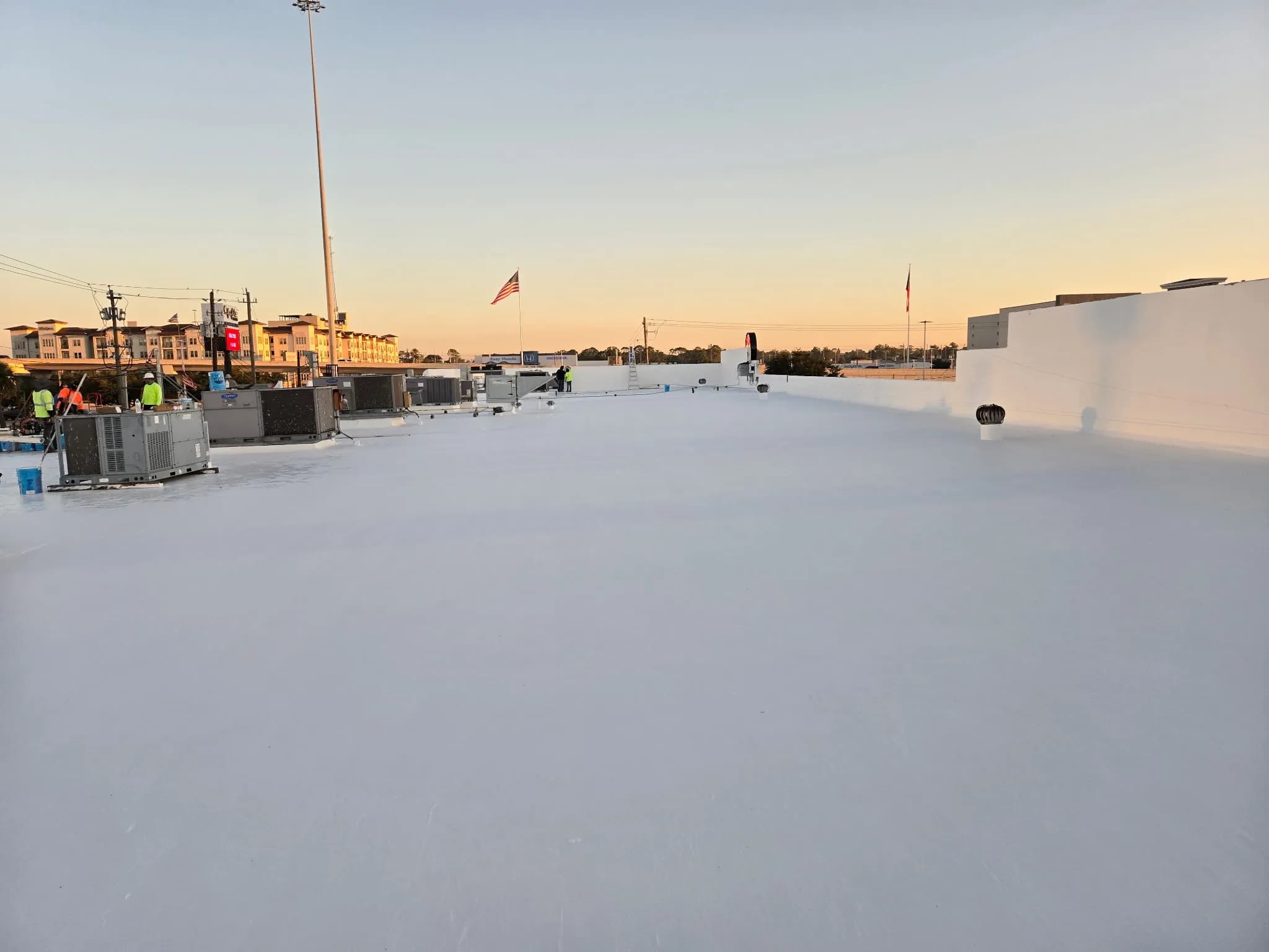 Restored white commercial roof under an open sky